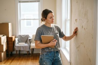 Femme examinant un mur intérieur avec peinture ancienne