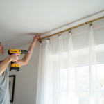 Personne fixant une tringle moderne au plafond lumineux